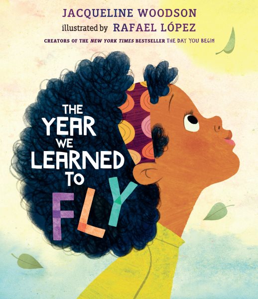 Book cover for The Year We Learned To Fly, showing a child with black curly hair looking upward at falling leaves.