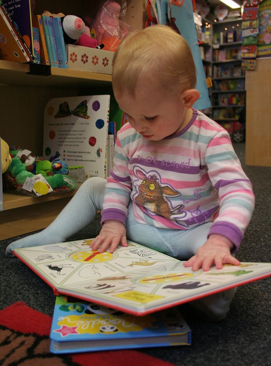 Young Child Looking At A Book In A Library