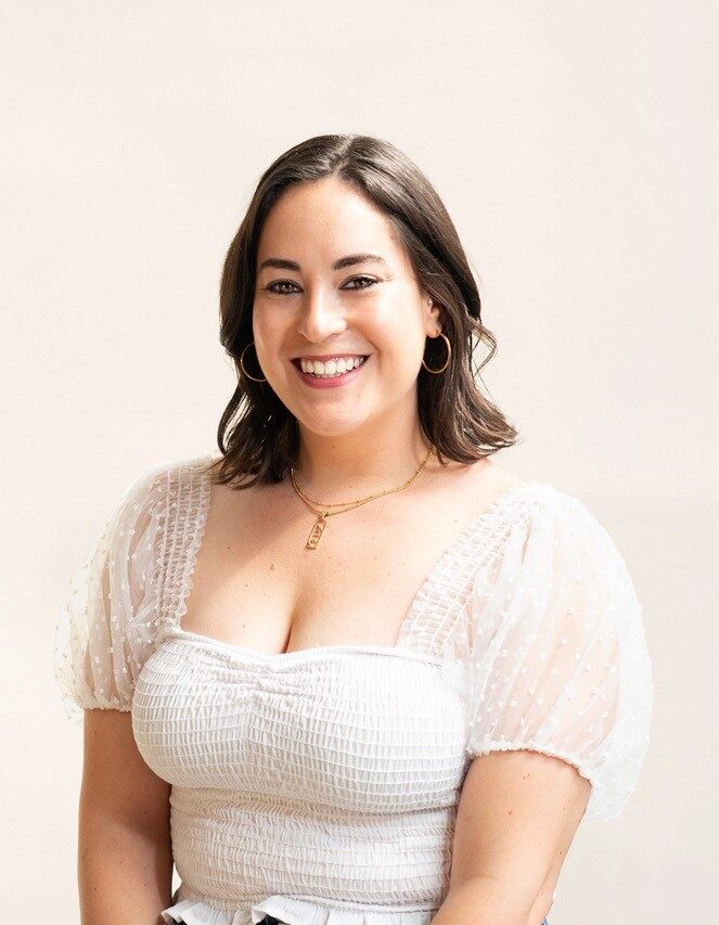 White person with shoulder length brown hair wearing a white shirt.