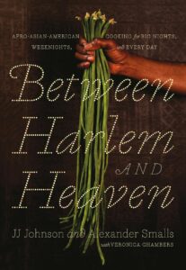 Front cover of Between Harlem and Heaven showing a Black persons hand clutching a handful of fresh produce