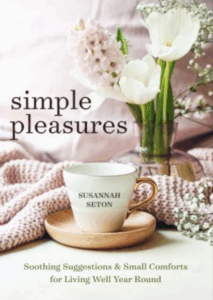 Front cover of Simple Pleasures: a photo of a white teacup, a throw blanket, and flowers
