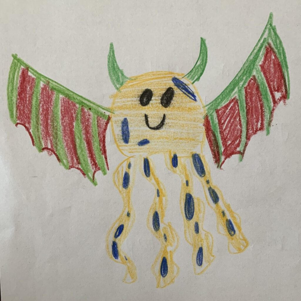 Crayon drawing of a smiling yellow octopus with blue spots. It has green horns and red and green dragon wings.