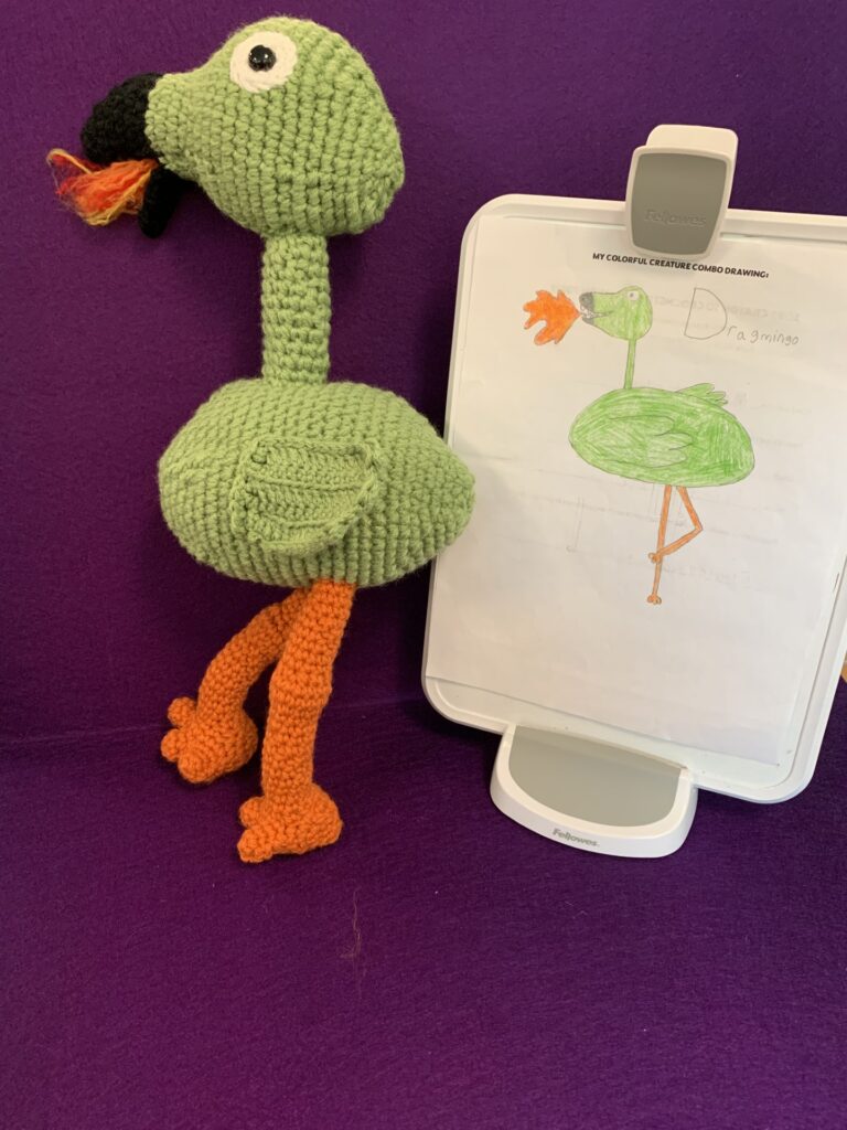 Crochet stuffy based on child's drawing which is also pictured. It's a green flamingo breathing fire.