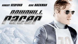 A man in ski gear and sunglasses stands before snowy mountains, with bold names displayed across the top against a winter backdrop.