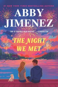 Book cover with an illustration of a couple and their dog sitting by a lake at sunset with fireworks lighting up the sky.